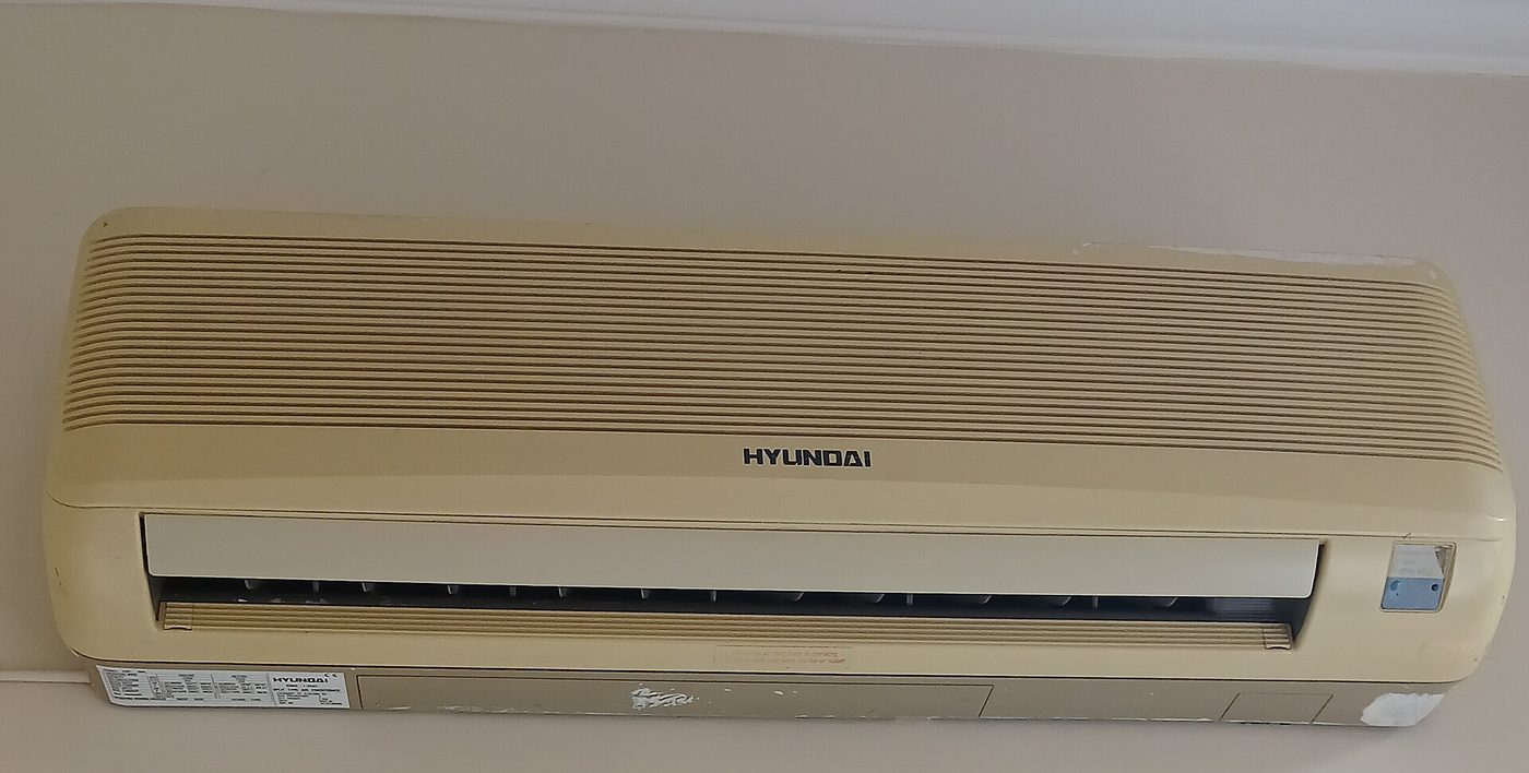 Aging yellowed mini split wall unit from an older refrigerant generation
